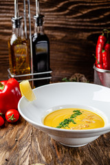 Serbian cuisine. Macedonian cream soup of chickpeas, carrots, onions, garlic, with chicken. Serving dishes in a restaurant in a white plate. background image, copy space text