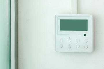 white wall air conditioning control panel with screen and control buttons, close up empty.