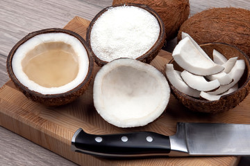 Sliced ​​coconut with natural milk and coconut on a wooden board. Vitamin Fruits. Healthy food