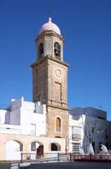 Fototapeta na wymiar Historical city gate with clock tower in the old town of Chiclana de la Frontera, Andalusia in Spain