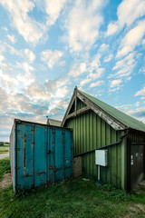 Fototapeta na wymiar Green farm building and blue cargo container.