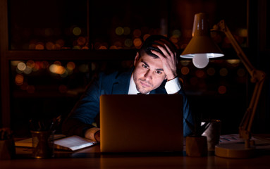 Entrepreneur At Laptop Thinking On Business Idea Overnight In Office