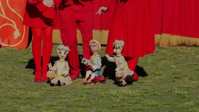 This video shows cute bear and animal puppets sitting and singing at an outdoor retro marionette theater show.