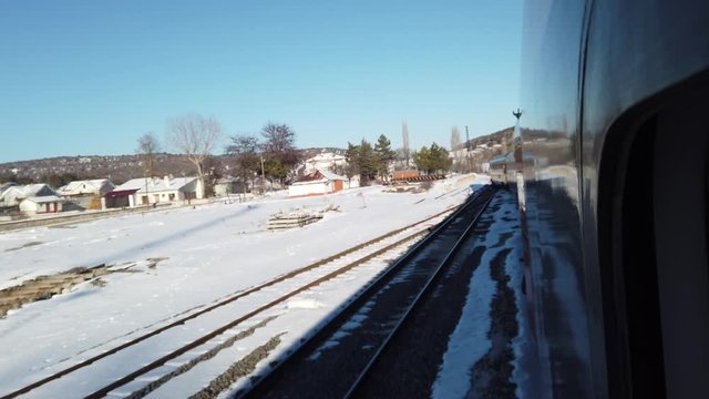Snowy Mountains, hillsides, forests, train travel in the steppes. it passes through railway stations in the mountain village. watching the journey through the window of the wagon