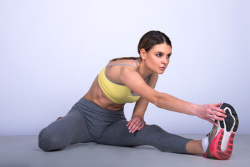 Fototapeta na wymiar beautiful young woman exercise on the floor, fit sporty Caucasian female, stretching fitness routine