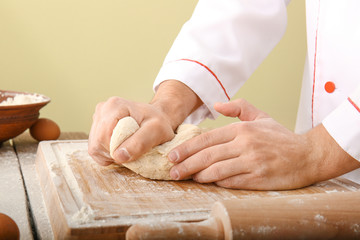 Man kneading dough in kitchen, closeup
