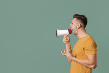 Screaming man with megaphone on color background