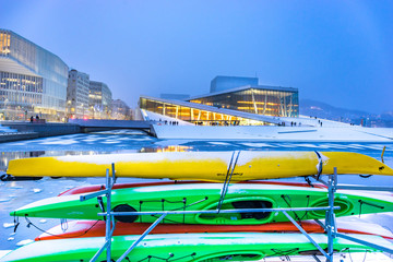 Fototapeta na wymiar National Oslo Opera House with colourful kayaks on the foreground after dusk. Oslo Opera House was opened on April 12, 2008 in Oslo, Norway