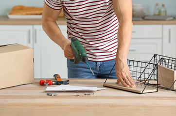 Young man assembling furniture at home