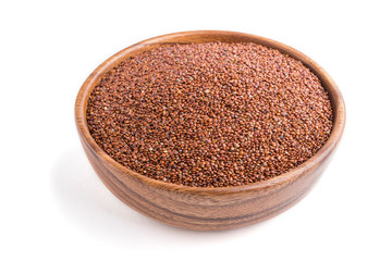 Wooden bowl with raw red quinoa seeds isolated on white background. Side view.