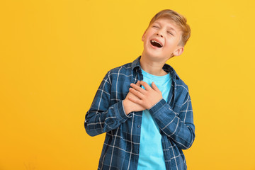 Happy little boy with healthy teeth on color background