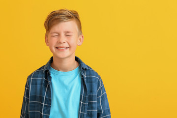 Happy little boy with healthy teeth on color background