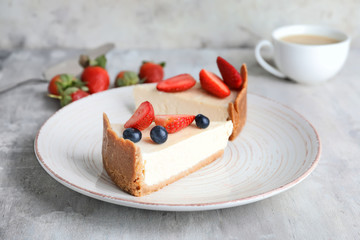 Plate with pieces of sweet tasty cheesecake on table