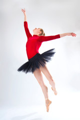 Obraz premium Young woman ballet dancer leaping in a black tutu.