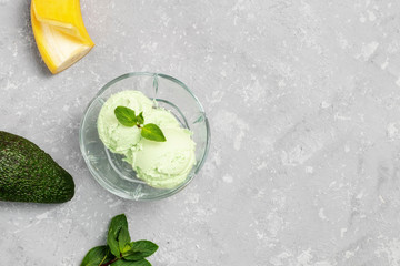 Vegan avocado ice cream with frozen banana, avocado and mint leaves on concrete neutral background