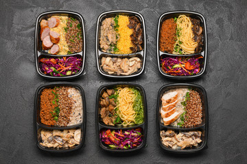 Containers with healthy food on dark background