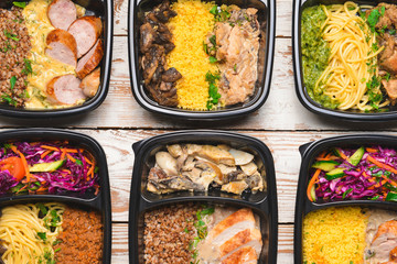 Containers with healthy food on wooden background