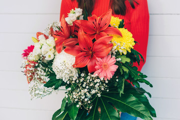 Woman holding beautiful bouquet with a variety of flowers