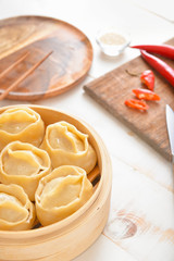 Steamer with oriental dumplings on table