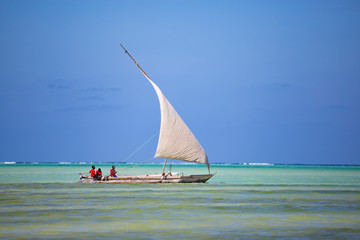 Old sailboat with african people on the water surface.  Zanzibar island , Tanzania, Africa.