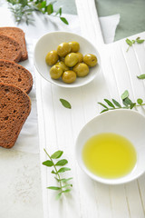 Bowl of tasty olive oil and bread on table