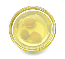 Bowl of tasty olive oil on white background