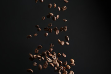 Falling coffee beans on dark background