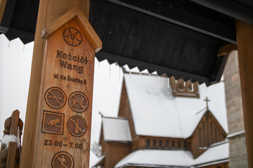 Information post at  wooden Wang Church in Karpacz. Temple in the background. 