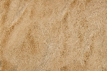 Natural crumpled leather texture, golden colored background
