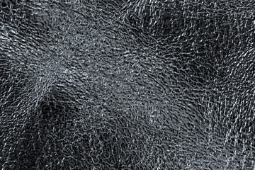 Texture of genuine patent leather with wrinkles, black background