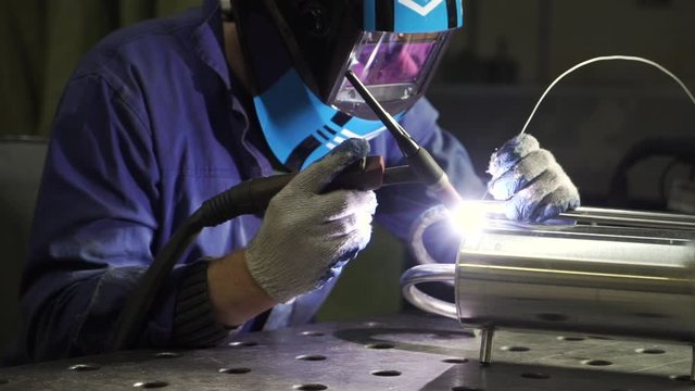 Industrial worker cutting and welding metal