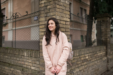 Happy young beautiful woman walking on the street. Portrait of a cheerful student standing on the street