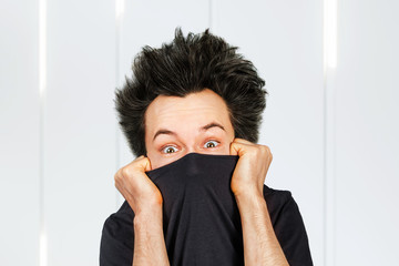 shaggy mad young man freak with long hair close his face on white background