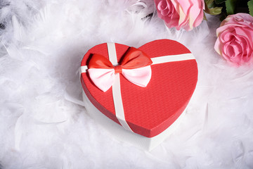 the box is heart shaped and the flowers are pink roses on the white fluff.international women day