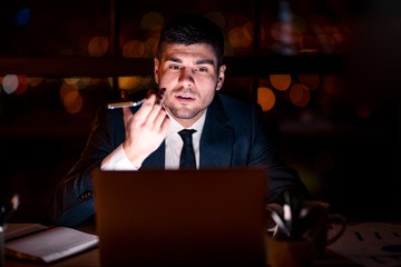 Businessman Using Voice Assistant On Mobile Phone Sitting In Office