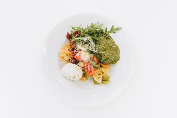 Top view of a healthy salad with rocket, mozarella and pesto sauce