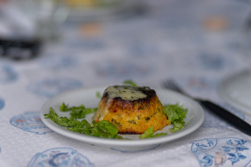 Small plate with appetiser and pieces of green leaf vegetable