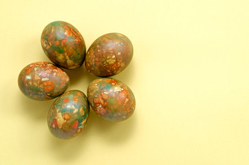 Marble modern trendy festive Easter eggs on the right frame in the form of a flower on a yellow background with a place for text, congratulations or a picture. Easter and spring concept