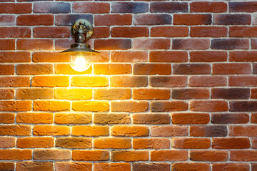 decorative wall inside the cottage made of red old brick with a lamp