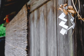 Shide (Shinto zigzag paper) at closed wood door in Kurama, Japan