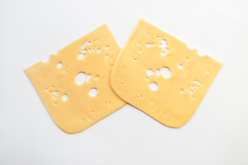 top view close-up of square cheese radamer slices isolated on a white background. Two pieces of...