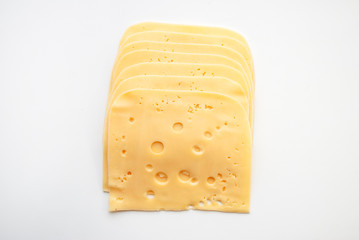 top view close-up of square cheese radamer slices isolated on a white background. Slices of swiss cheese.Maasdam - Dutch hard cheese with large holes.