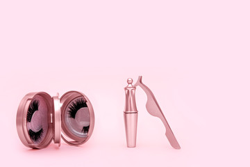 Magnetic fake eyelash in mirror kit, eye liner, tweezers isolated on pink background. Eyelash...