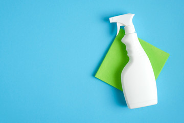 White cleaner spray bottle and green rag. Flat lay, top view. House cleaning service and...