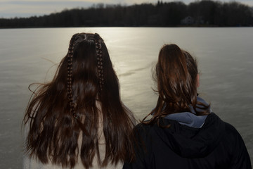 Friends looking at frozen lake