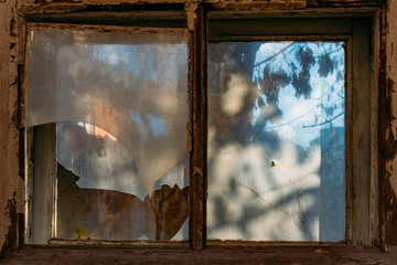 Broken window of old abandoned wooden building
