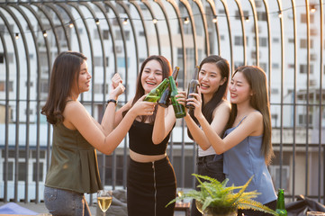 Group of Attractive young Asian cute women having a party. Girls drinking beer and feeling happy enjoy, with funny smiley faces. Party on holiday and Night lifestyle concept.