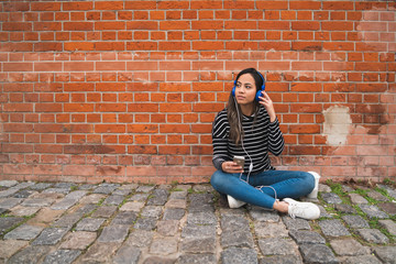 Woman listening music and using smartphone.