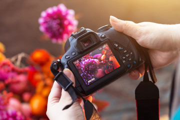Camera on hands closeup. Making nature photo and video with flowers