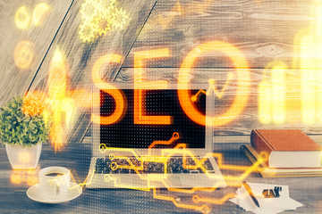 Multi exposure of table with computer and seo drawing hologram. Search optimization concept.